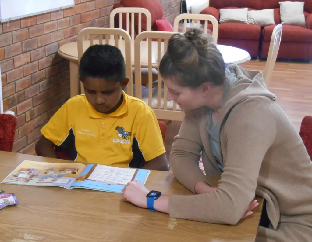 child reading with teacher