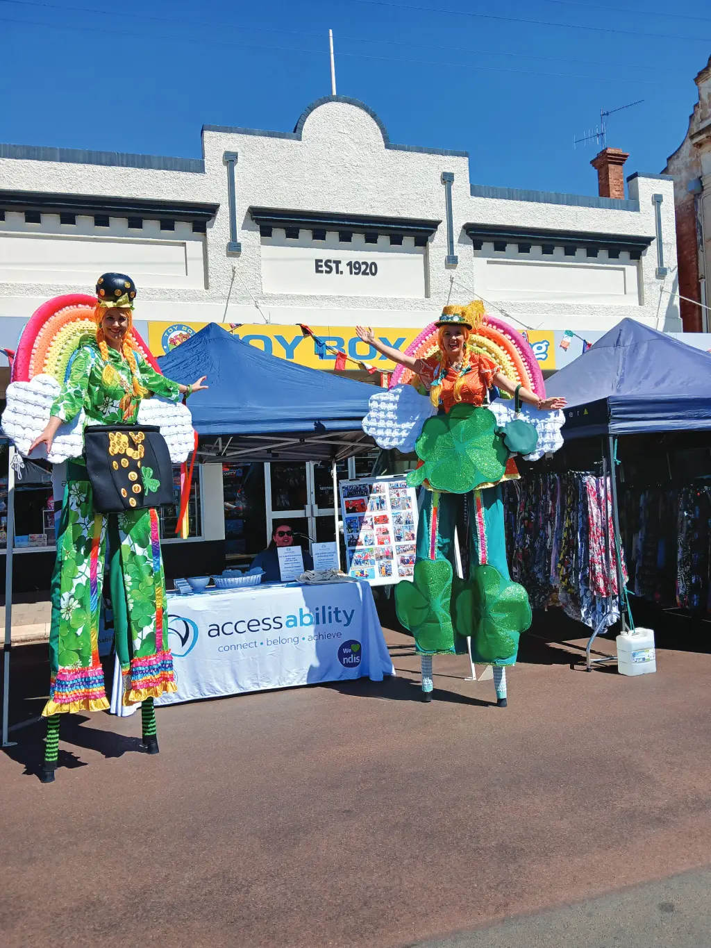 women on stilts beside stand